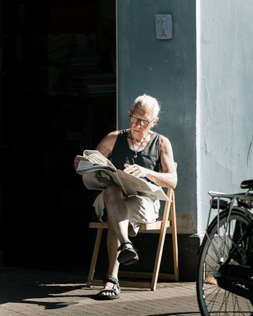 A young woman with long brown hair, smiling, holding an empty cardboard box labeled 'FRAGILE GLASS' in uppercase red letters, during a home relocation process. She is standing indoors against a light